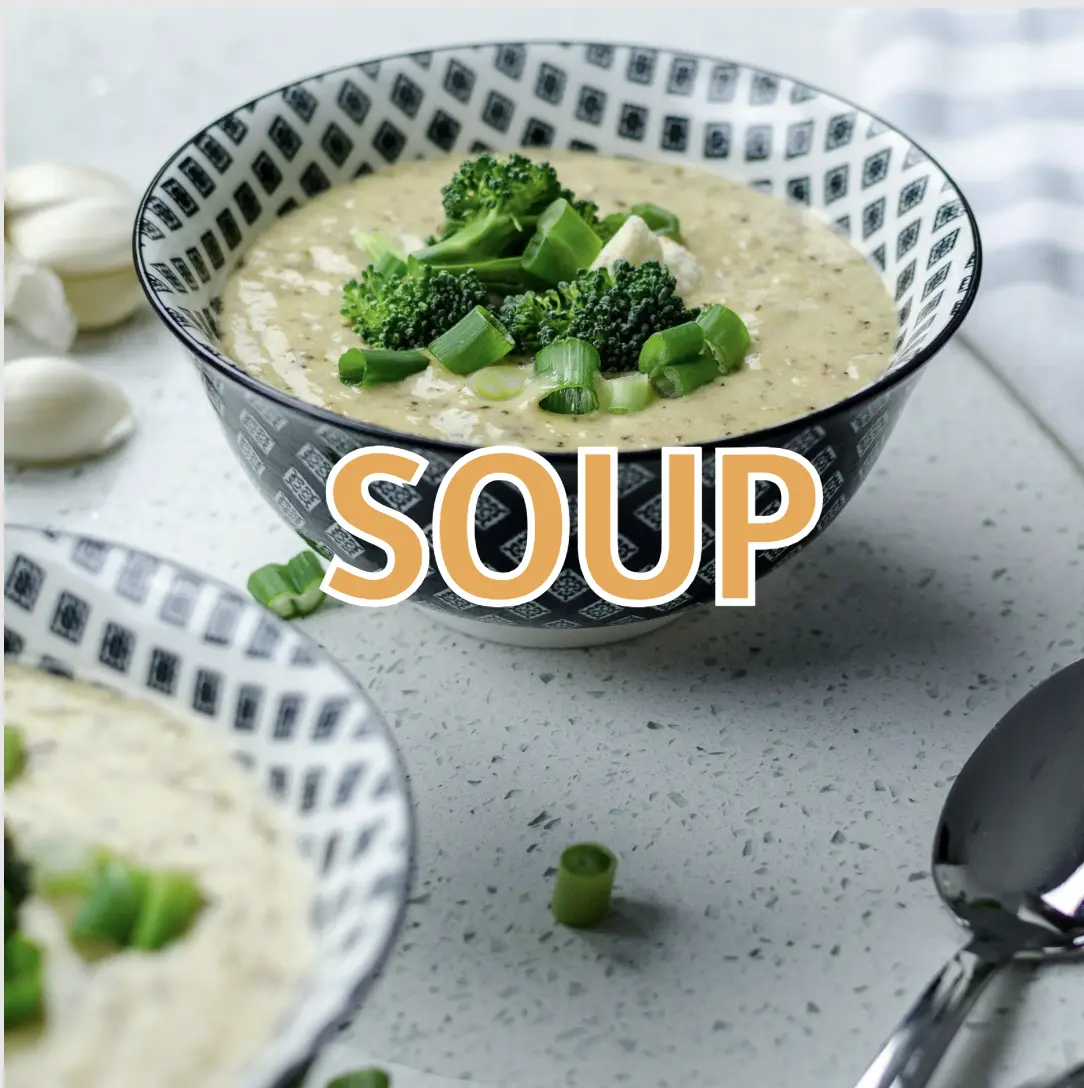 A warm bowl of soup with vegetables and fresh herbs.